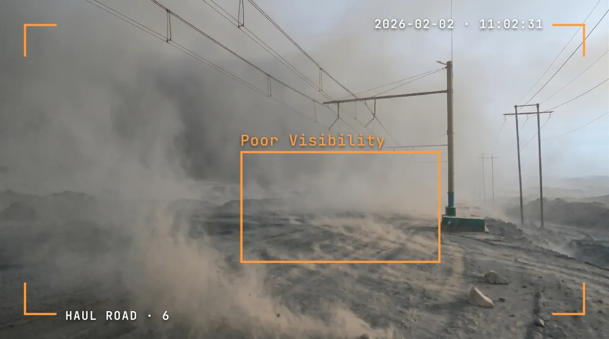 Haul road camera view in heavy dust with visibility flagged as poor.